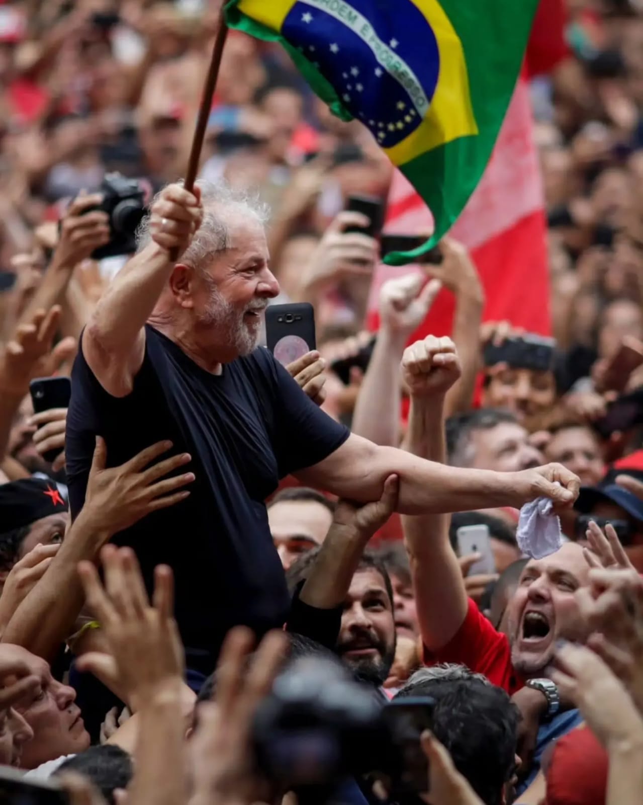 Lula em meio à multidão com bandeira do Brasil.